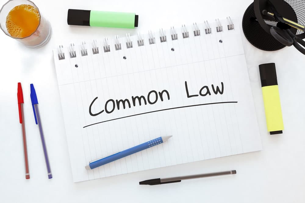 Common-Law Separation Lawyers in Calgary Alberta portrayed by pens and markers surrounding a notepad that says "common law" near a gavel.